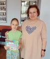 Dziecko pozuje do zdjęcia z instruktorką i dyplomem
